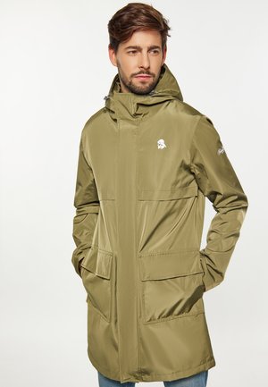 Veste imperméable vert olive avec capuche, comportant deux grandes poches avant et un petit logo sur la poitrine. Texture lisse et brillante.