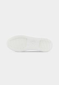 Λευκή σόλα παπουτσιού με οδοντωτό μοτίβο πρόσφυσης, κυκλικό λογότυπο στο κέντρο και υφασμένες περιοχές κράτησης στη φτέρνα και στο μπροστινό μέρος του ποδιού.