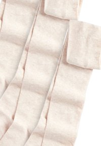 Collant beige chiaro realizzati in un tessuto morbido e elastico; presentano una texture liscia e ampie cuffie superiori per una vestibilità sicura.