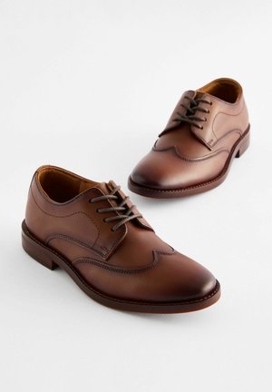 Chaussures en cuir marron avec un bout rond, un design à ailes et des lacets gris. Présentent des détails cousus et une semelle lisse et basse.