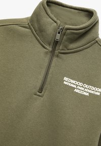 Pullover in felpa di colore verde oliva con colletto alto e chiusura a zip quarti. Presenta un logo testuale bianco: "REDWOOD OUTDOOR NATIONAL PARK ADVENTURE ARIZONA."