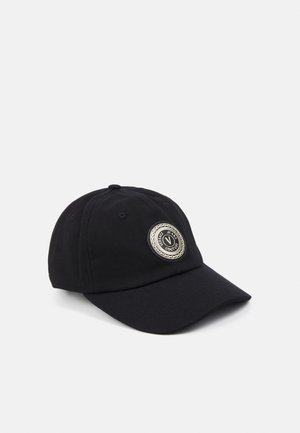 Casquette de baseball noire avec une visière courbée et un écusson rond du logo Versace Jeans Couture sur le panneau avant, sur fond blanc.