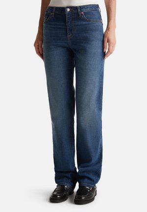 Jean droit bleu indigo avec taille mi-haute. Il présente un design classique à cinq poches, des rivets en métal et un léger délavage sur les jambes.