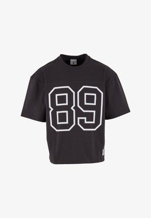 Tricou negru cu mânecă scurtă și număr mare „89” conturat alb pe față și o etichetă mică pătrată aproape de tivul de jos.