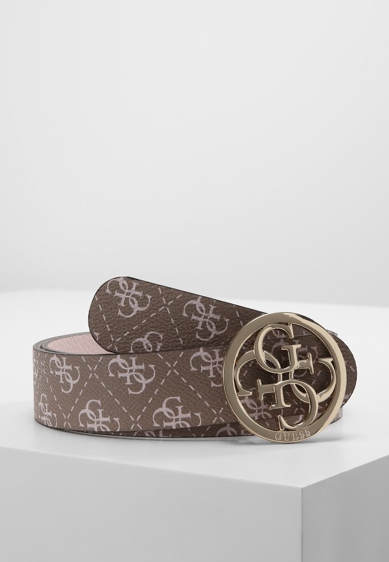Ceinture Guess marron avec un motif de logo répétitif et une boucle ronde dorée avec des initiales entrelacées, présentée sur une surface blanche.
