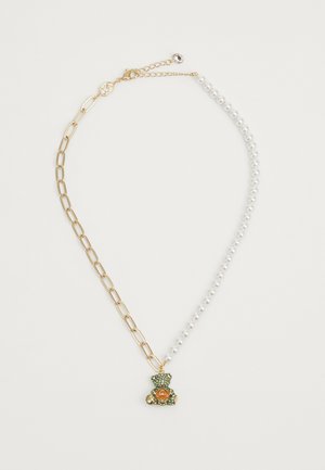 Collier en or avec pendentif vert et orange orné de cristaux. Un côté est constitué d'un fil de perles ; le design associe textures et couleurs.