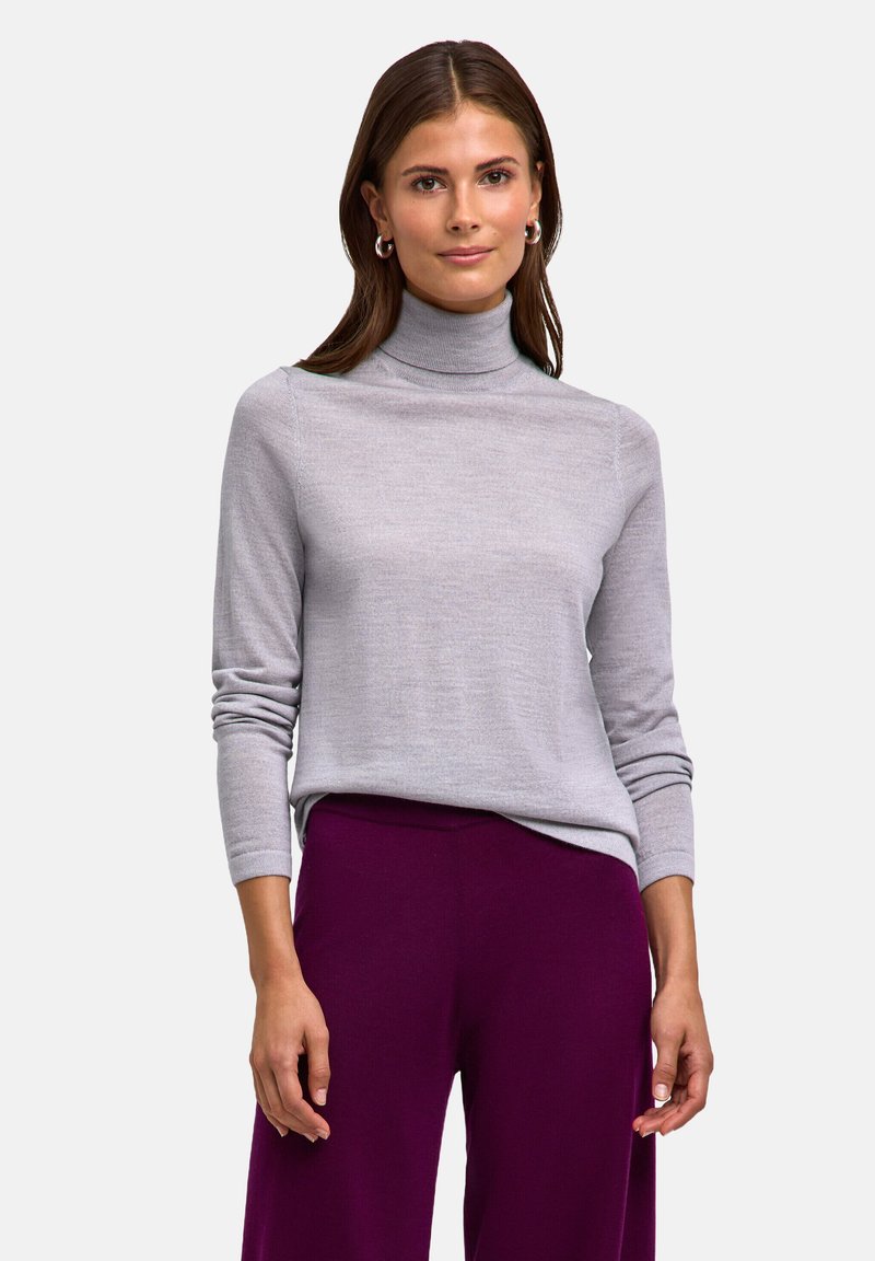 Maglione grigio a collo alto con maniche lunghe e vestibilità comoda, realizzato in un tessuto morbido e leggero; abbinato a pantaloni a gamba larga viola.