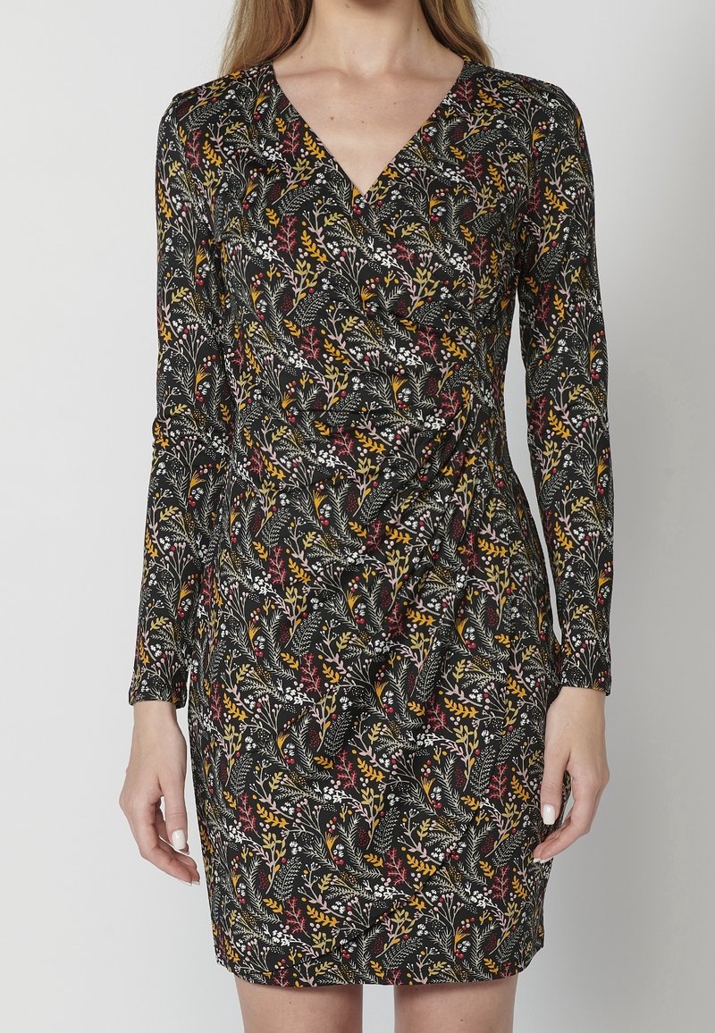 Czarna sukienka z długimi rękawami, dekoltem w kształcie litery V oraz kwiatowym wzorem w czerwonych, żółtych i białych akcentach. Gładki materiał o dopasowanej sylwetce.