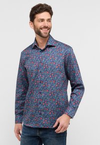 Heren overhemd met lange mouwen in marineblauw met een bloemenpatroon. Voorzien van een knoopsluiting aan de voorkant, een kraag en een gestructureerde stof. Geschikt voor casual draag.