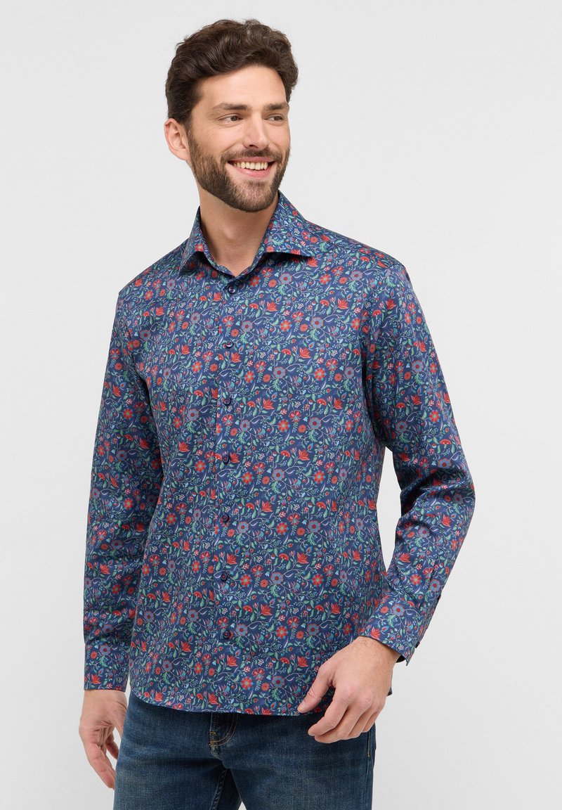 Heren overhemd met lange mouwen in marineblauw met een bloemenpatroon. Voorzien van een knoopsluiting aan de voorkant, een kraag en een gestructureerde stof. Geschikt voor casual draag.