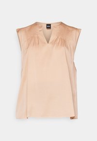 Blouse sans manches en satin beige avec col en V, plis verticaux subtils sur les épaules et coupe décontractée.