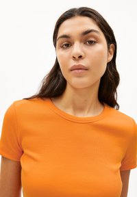 Oranje geribde t-shirt met een ronde halslijn en korte mouwen, met een gladde textuur en een aansluitende pasvorm.