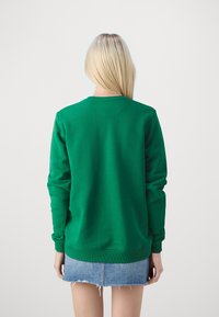 Roheline sweatshirt, mis on valmistatud pehmest kangast, omab ümmargust kaelust ja pikki varrukaid. Tagaküljel on lihtne disain koos soonikkoes mansettide ja alumise äärtega.