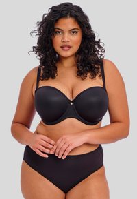 Ensemble de lingerie noire comprenant un soutien-gorge à armatures rembourrées et une culotte taille haute. Tissu lisse avec bretelles ajustables et un subtil accent central.