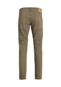Pantaloni slim-fit marroni visti da dietro con due tasche posteriori e un'etichetta in pelle color cuoio sulla cintura.