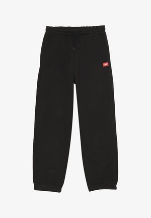 Pantaloni della tuta neri realizzati in tessuto morbido, con vita elasticizzata e cordino, tasche laterali e una piccola etichetta rossa sul lato sinistro.