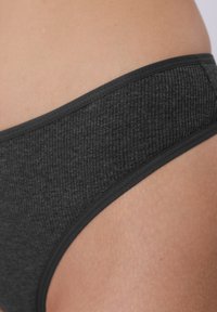 Culotte bikini côtelée noire avec une ceinture élastique lisse, présentant une surface texturée et des bords nets.