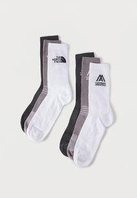Δύο σετ από τρεις ριμπ βαμβακερές κάλτσες σε μαύρο, γκρι και άσπρο, με λογότυπα The North Face και Mountain Athletics στις λευκές κάλτσες.