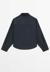 Chemise à carreaux bleu foncé à manches longues vue de dos avec poignets boutonnés et ourlet incurvé.