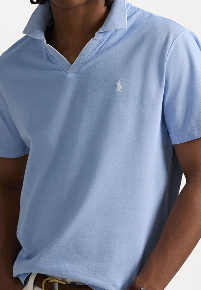 Koszulka polo w jasnym niebieskim kolorze, wykonana z teksturowanej tkaniny, z kontrastowym kołnierzykiem, krótkimi rękawami oraz małym białym logo na piersi.