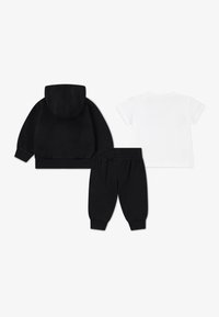 Otrobek za otroke, ki vsebuje tri kose: črna kapuca z elastičnimi zapestji, črne trenirke in bela majica s kratkimi rokavi. Mehka tkanina, sproščen dizajn.