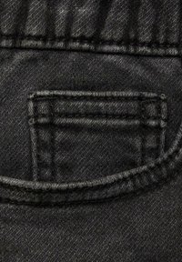 Svart denimtyg med en liten bakficka. Synlig sömnad och texturdetaljer förstärker designen. Slät yta med lätt lyster.