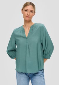 Teal, losvallende blouse met een V-hals en geplooide details, met driekwart mouwen en elastische manchetten, gemaakt van lichtgewicht stof.