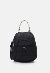 Zwarte gewatteerde rugzak met een gestructureerd oppervlak, verstelbare schouderband, een wit patroon handvat en een voorvak met gespdetail.