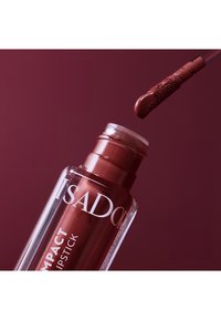 Rossetto liquido rosso in un contenitore trasparente con applicatore affusolato, che mostra una consistenza liscia e cremosa e una finitura lucida.