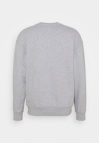 Sweat-shirt gris avec un col rond, des manches longues et des poignets côtelés. Tissu doux et texturé avec une coupe décontractée. Aucun motif visible.