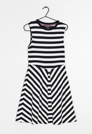 Black and white striped sleeveless dress with a fitted bodice and flared, chevron-patterned skirt. Made from a soft, stretch fabric.
