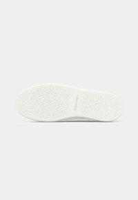 White rubber shoe sole with textured pattern featuring "Calvin Klein" branding. Smooth finish with non-slip grip design.