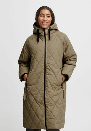Manteau long matelassé en vert olive, doté d'une capuche, d'une fermeture éclair frontale et de cordons noir. Deux poches latérales et une coupe décontractée.