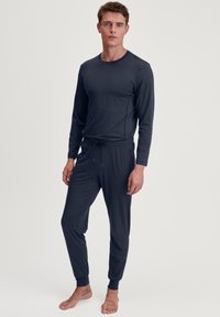 Donkerblauwe lange mouwen top en bijpassende joggingset, gemaakt van zachte stof, met een slim fit, elastische tailleband en boorden bij de enkels.