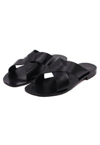 Sandali estivi neri in pelle con fascette incrociate, suola piatta, texture liscia, design open-toe e stile minimalista.