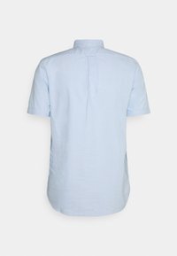 Camicia azzurra a maniche corte con yoke posteriore e piega, realizzata in un tessuto liscio. Presenta un colletto classico e un orlo dritto.