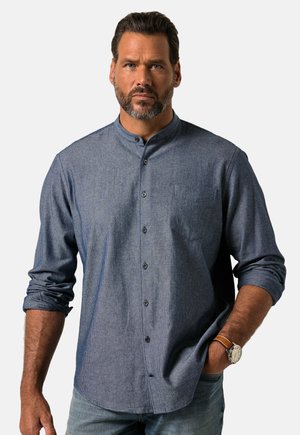 Camisa de algodón de botones en azul oscuro con cuello mao, un bolsillo en el pecho y mangas enrolladas. Textura suave, ajuste casual.