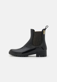 Zwarte rubberen Chelsea-boots met een glanzende afwerking, gestructureerde zwarte elastische zijpanelen en een lage, groefvormige zool. Gouden hardware-details aanwezig.