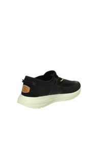 Sneaker in tessuto nero con suola crema, caratterizzato da un accento metallico decorativo, tacco in gomma e patch con logo sul retro.