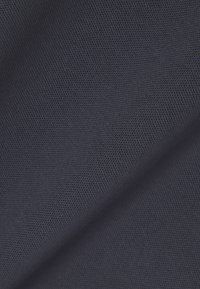 Donkergrijze stof met fijn, dicht geweven textuurpatroon, met lichte plooien en schaduwwerking.