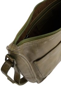 Olivově zelená kožená crossbody taška s prostorným interiérem, dvojitým zipovým uzávěrem a přední kapsou. Texturovaný povrch s čistým šitím.