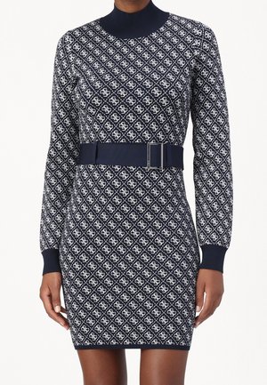 Mini-robe à manches longues motif bleu marine et blanc, col montant et large ceinture bleu marine avec boucle rectangulaire à la taille.