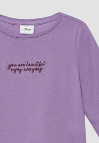Lila Langarmshirt mit rundem Ausschnitt und besticktem Text "du bist schön, genieße jeden Tag" in dunklerem lila Faden.