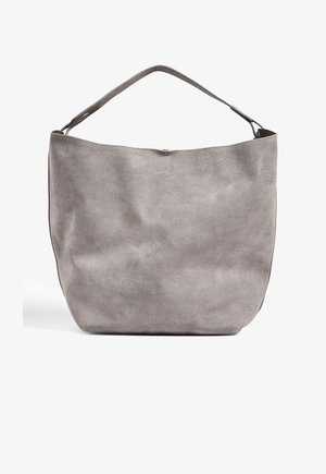 Harmaa mokkanahkainen hobo-laukku, jossa on leveä, kaareva yläosa ja yksittäinen olkahihna. Pehmeä tekstuuri ja muotoutumaton muoto, jossa on vain vähän metalliosia.