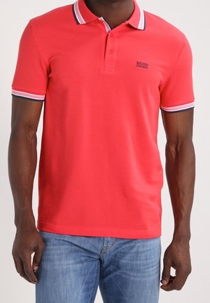 Rode poloshirt met een platte kraag met twee knopen, gestreepte kraag en manchetten, en een klein geborduurd logo op de borst. Gemaakt van katoen, met een ontspannen pasvorm.