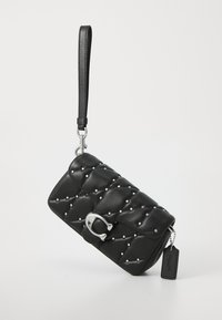 Quilted black leather clutch with silver hardware, adorned with small decorative studs, featuring a detachable wrist strap and tag.