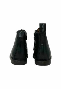 Stivaletti neri in pelle con finitura lucida, pannelli laterali elastici e marchio sui talloni, caratterizzati da una punta arrotondata e una suola resistente.