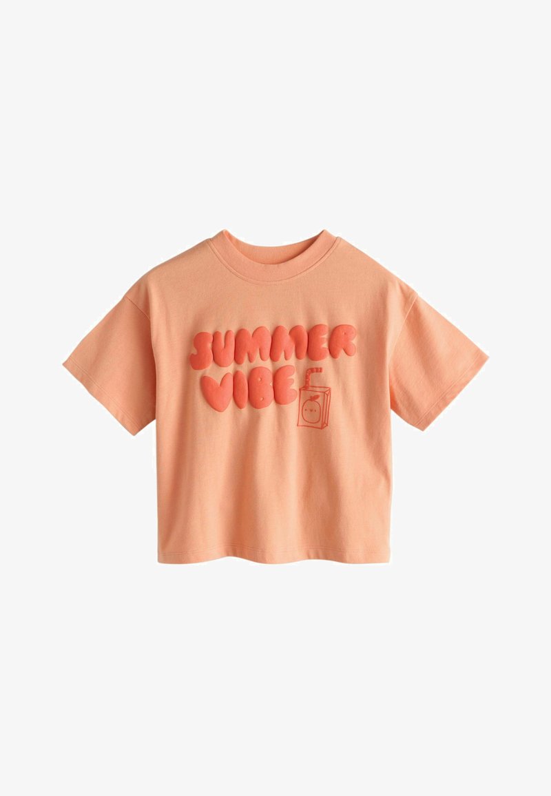 T-shirt à manches courtes couleur pêche avec "SUMMER VIBE" en lettres grasses et gonflées et un petit motif de boîte de jus sur le devant.