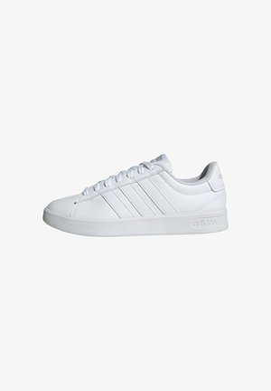 Sneaker Adidas bianco basso con tre strisce laterali, chiusura con lacci, collarino imbottito e suola brandizzata su sfondo bianco.