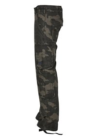 Pantalones cargo en estampado de camuflaje oscuro. Fabricados con tela duradera y múltiples bolsillos. Presentan un corte relajado y cordón en el dobladillo.